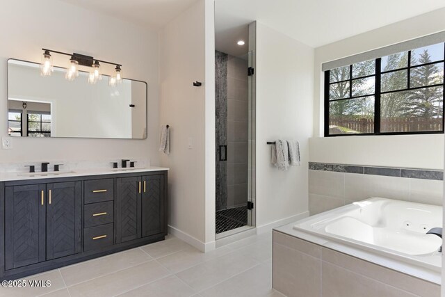 207 Aidan Rd, Eagle, CO 81631 - bathroom featuring tile patterned floors, a shower stall, a jetted tub, double vanity, and baseboards
