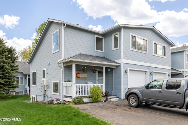 townhome / multi-family property featuring covered porch, a front yard, an attached garage, and driveway