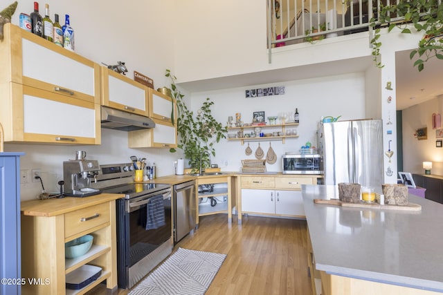 705 Nogal Rd Unit C9, Eagle, CO 81631 - kitchen with stainless steel appliances, under cabinet range hood, light wood finished floors, open shelves, and butcher block countertops