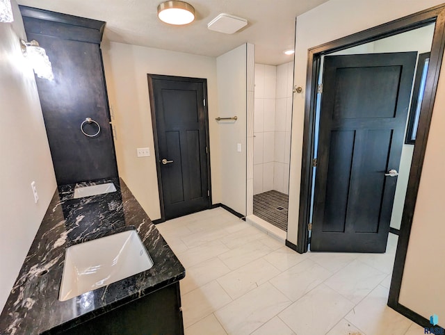 bathroom with double sink vanity, tile flooring, and tiled shower