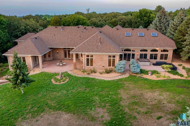 back of property featuring a yard and a patio area