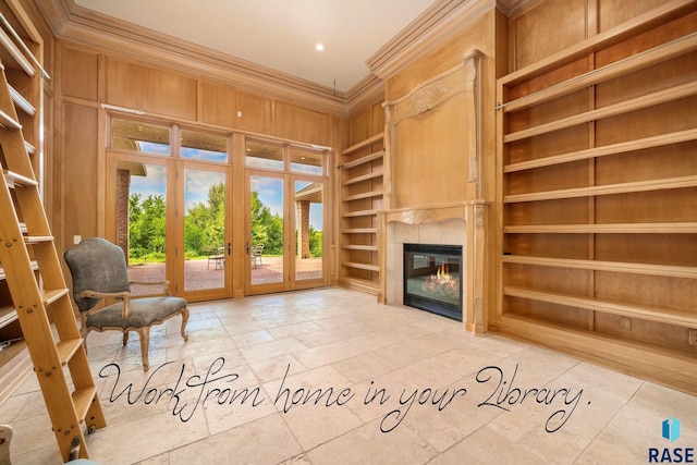 interior space featuring a tile fireplace, french doors, wooden walls, built in shelves, and ornamental molding