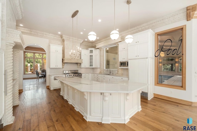 kitchen featuring white cabinets, pendant lighting, stainless steel appliances, and a large island