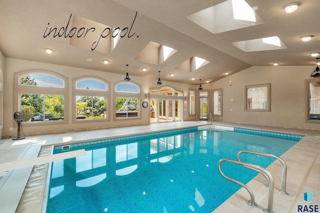 view of pool featuring a skylight and a diving board