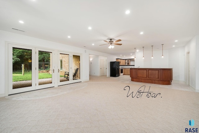 unfurnished living room with light carpet and ceiling fan