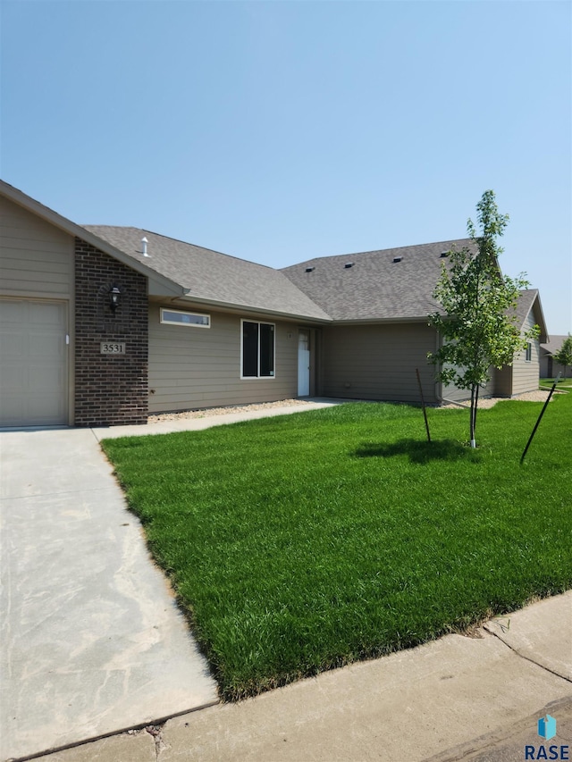 single story home featuring a garage and a front lawn