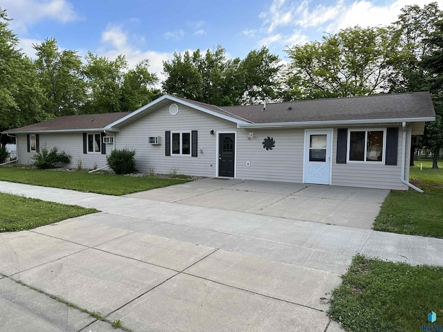 single story home with an AC wall unit and a front lawn