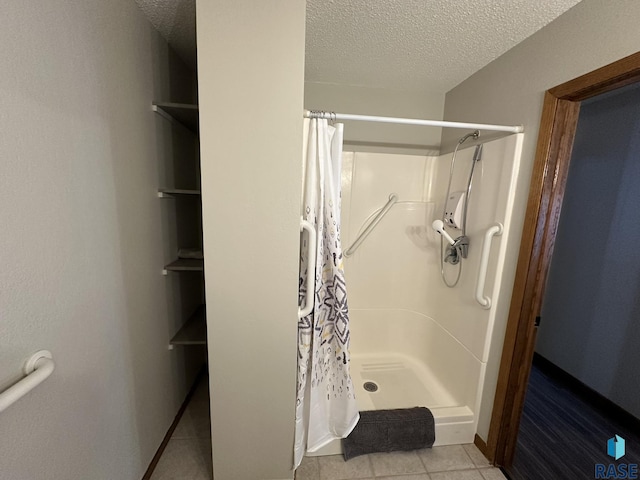 bathroom with tile patterned floors, walk in shower, and a textured ceiling