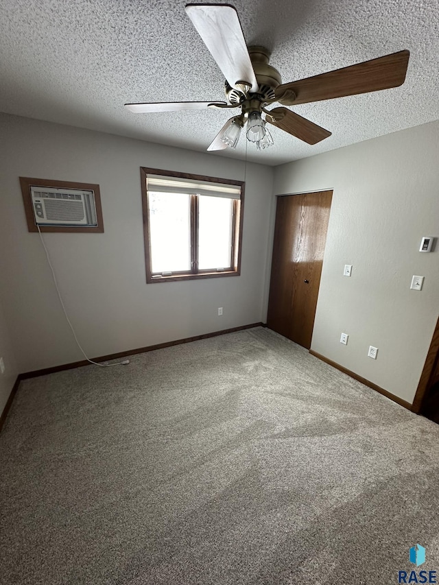 empty room with carpet, ceiling fan, a textured ceiling, and a wall mounted AC