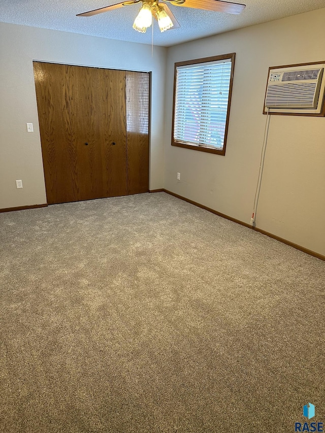 unfurnished bedroom with carpet, ceiling fan, a textured ceiling, and a closet