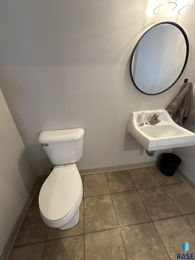 bathroom with tile patterned flooring, toilet, and sink