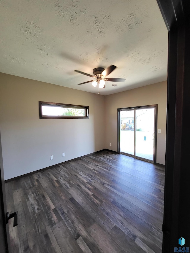 5304 S Bahnson Ave, Sioux Falls, SD 57108 - empty room featuring dark wood-type flooring, a textured ceiling, healthy amount of natural light, a ceiling fan, and baseboards