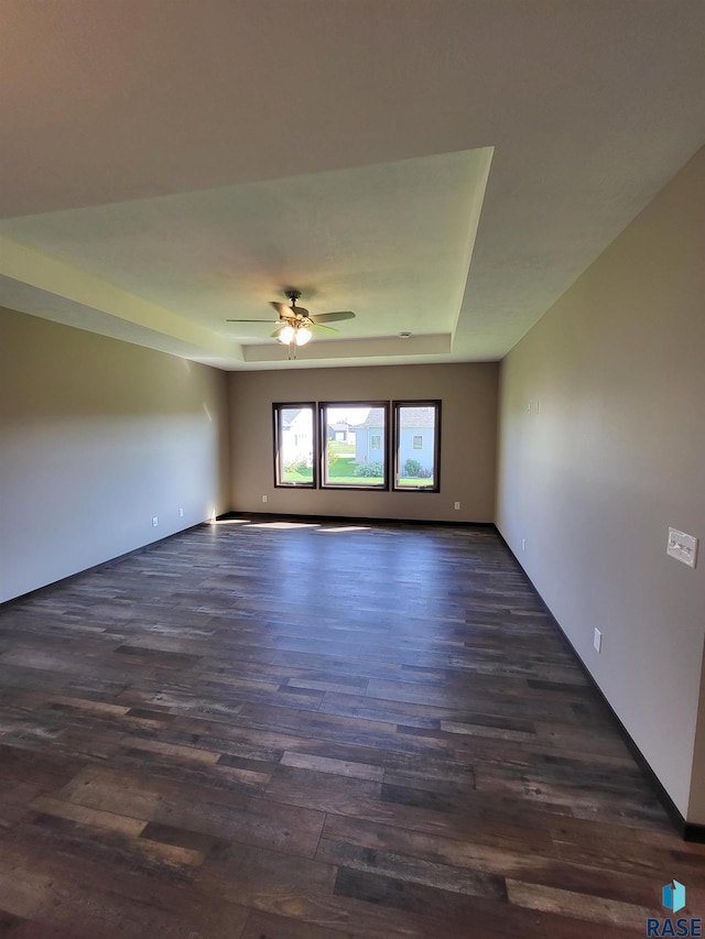 5304 S Bahnson Ave, Sioux Falls, SD 57108 - spare room featuring dark wood-style floors, ceiling fan, a tray ceiling, and baseboards