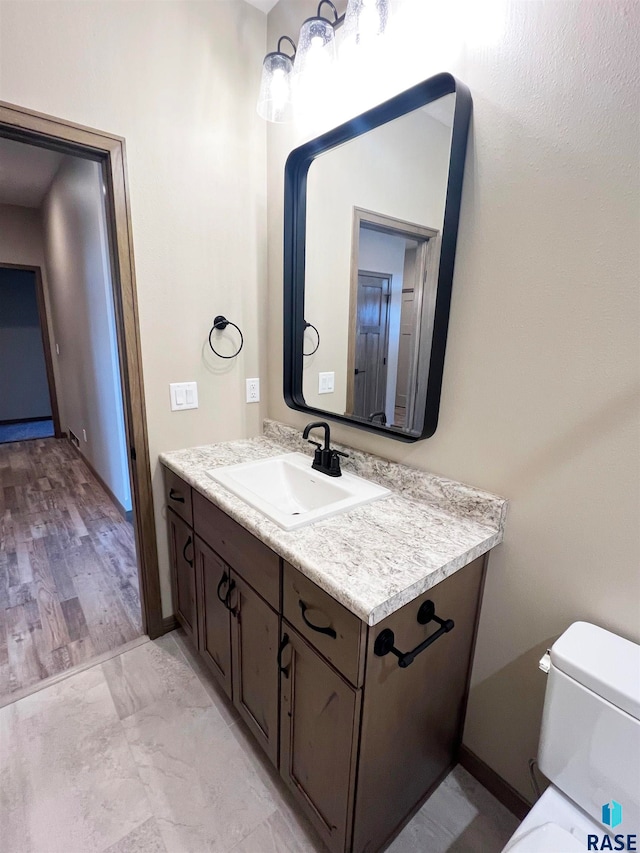 bathroom with tile flooring, large vanity, and toilet