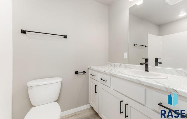 bathroom with vanity, toilet, and wood-type flooring