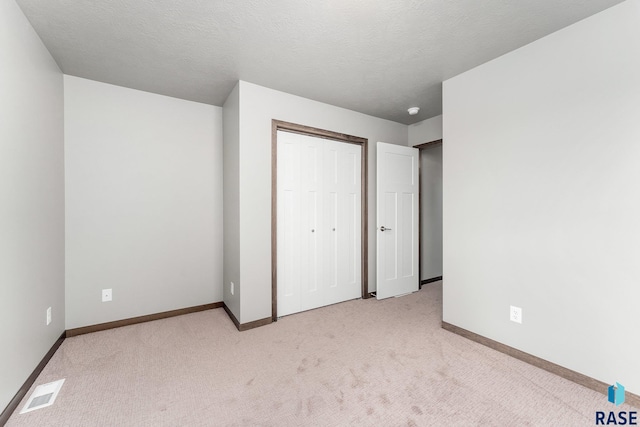 117 N Summit Ave, Tea, SD 57064 - unfurnished bedroom with light colored carpet, a textured ceiling, and a closet