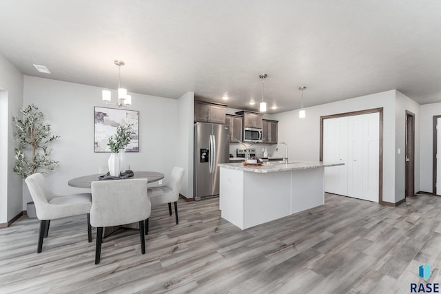 117 N Summit Ave, Tea, SD 57064 - kitchen with sink, an inviting chandelier, hanging light fixtures, stainless steel appliances, and a center island with sink