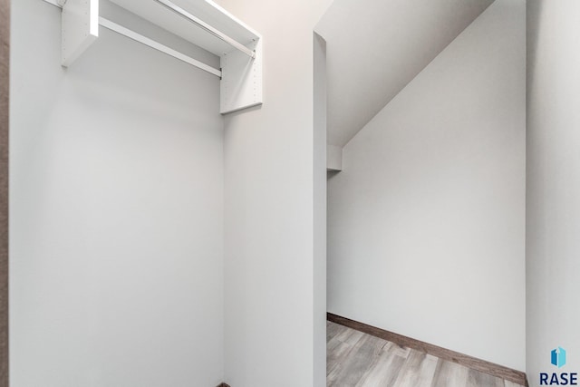 walk in closet with light hardwood / wood-style flooring