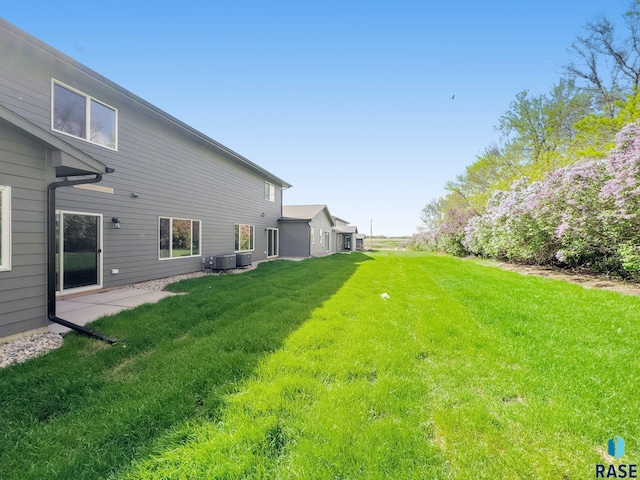 view of yard with central AC and a patio area