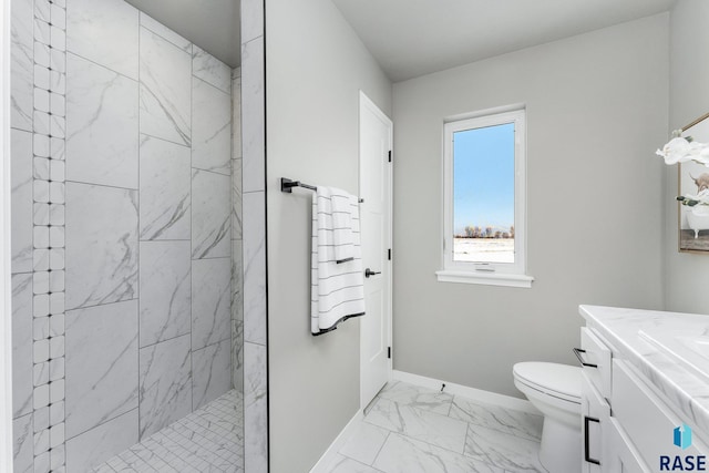 bathroom featuring vanity, toilet, and a tile shower