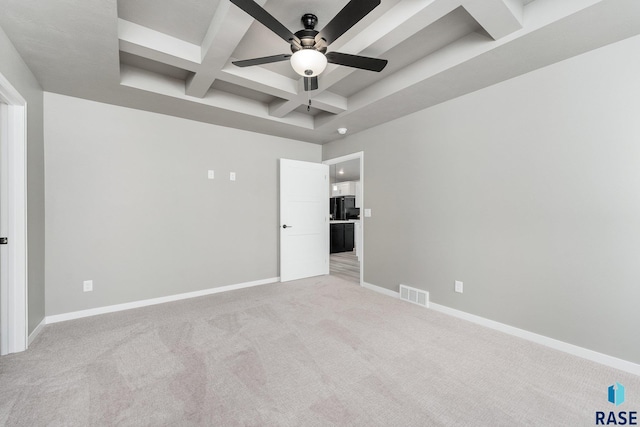 unfurnished bedroom with ceiling fan, beam ceiling, coffered ceiling, black fridge, and light colored carpet