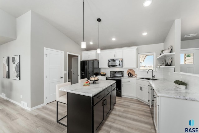 kitchen featuring sink, white cabinetry, a kitchen island, pendant lighting, and black appliances