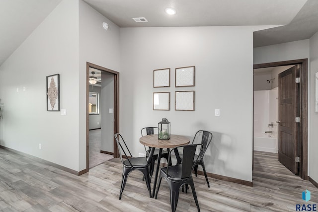 dining room featuring lofted ceiling, light hardwood / wood-style floors, and ceiling fan