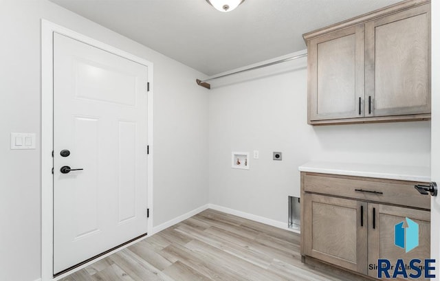 laundry area featuring cabinets, washer hookup, light hardwood / wood-style flooring, and electric dryer hookup