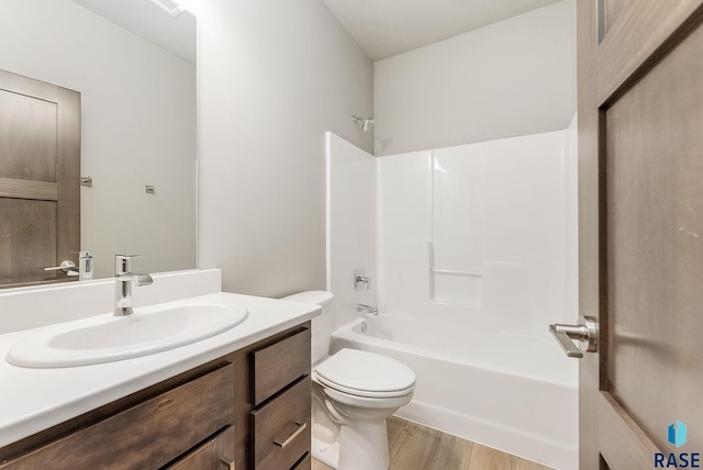 full bathroom featuring wood-type flooring, bathtub / shower combination, vanity, and toilet