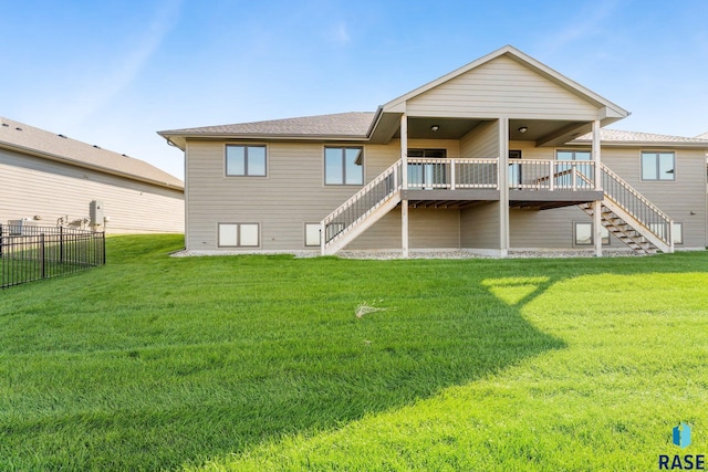 back of property featuring a deck and a lawn