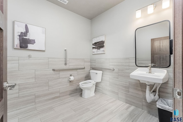 1437 N Mae Pl, Tea, SD 57064 - bathroom featuring tile patterned floors, toilet, sink, and tile walls