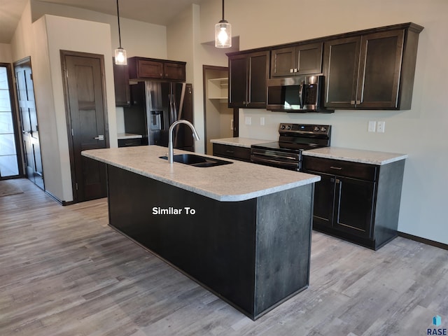 kitchen featuring pendant lighting, sink, dark brown cabinetry, an island with sink, and stainless steel appliances