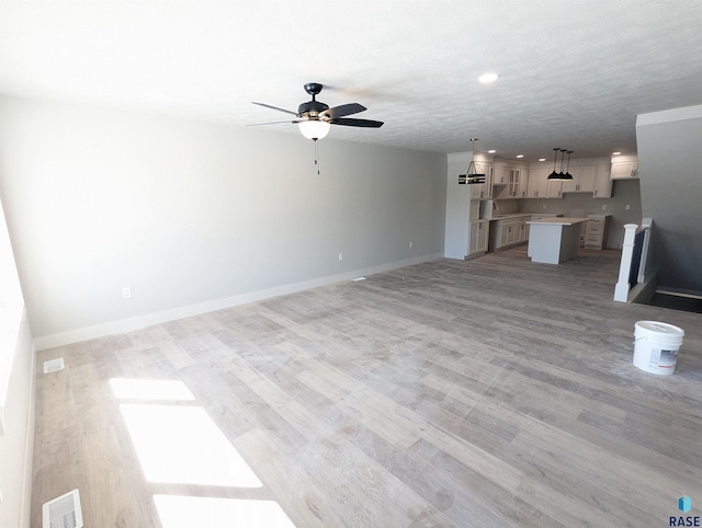 unfurnished living room featuring light hardwood / wood-style floors and ceiling fan