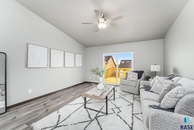 living room with ceiling fan, light wood-type flooring, and vaulted ceiling