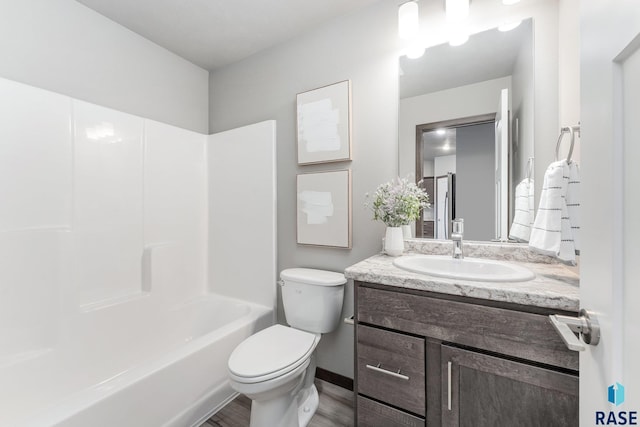 full bathroom with bathtub / shower combination, vanity, hardwood / wood-style flooring, and toilet