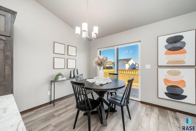 dining area featuring lofted ceiling, a chandelier, and light hardwood / wood-style flooring