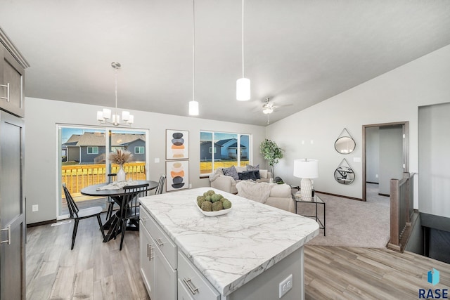 kitchen featuring white cabinetry, a center island, hanging light fixtures, and light wood-type flooring