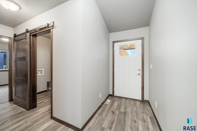 foyer entrance featuring light hardwood / wood-style floors and a barn door