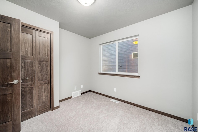 unfurnished bedroom featuring light carpet