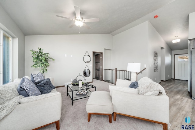 living room with hardwood / wood-style flooring, ceiling fan, and vaulted ceiling