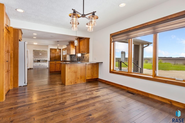 kitchen featuring white fridge, tasteful backsplash, pendant lighting, and dark hardwood / wood-style flooring