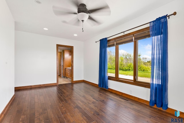 spare room with dark wood-type flooring and ceiling fan