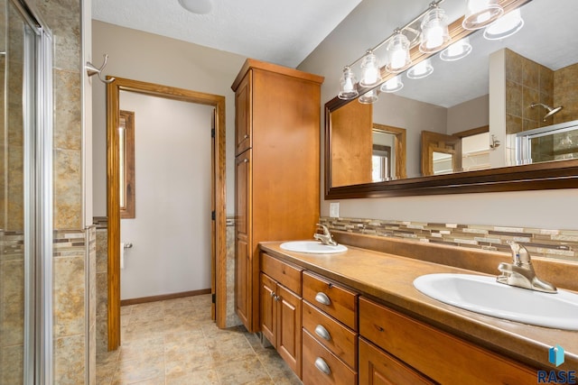 bathroom with a shower with door, dual sinks, tile flooring, and large vanity