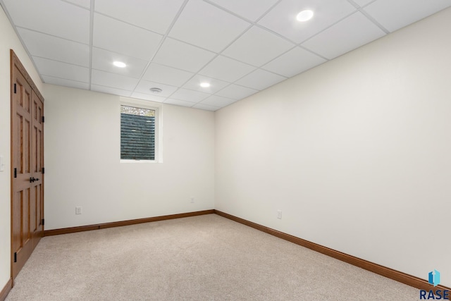 unfurnished room featuring a paneled ceiling and carpet flooring