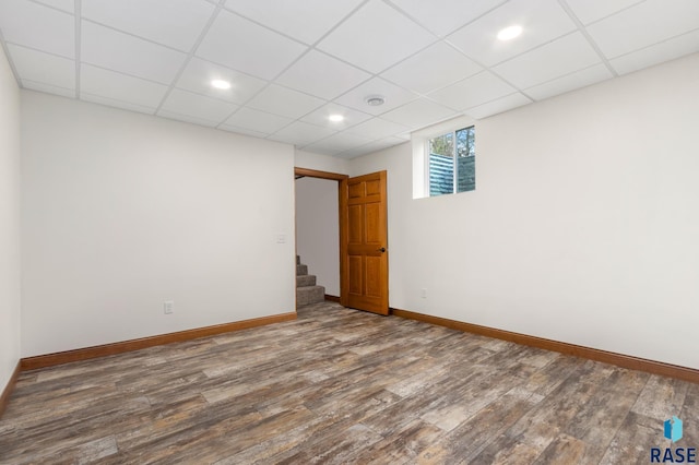 spare room with hardwood / wood-style flooring and a drop ceiling