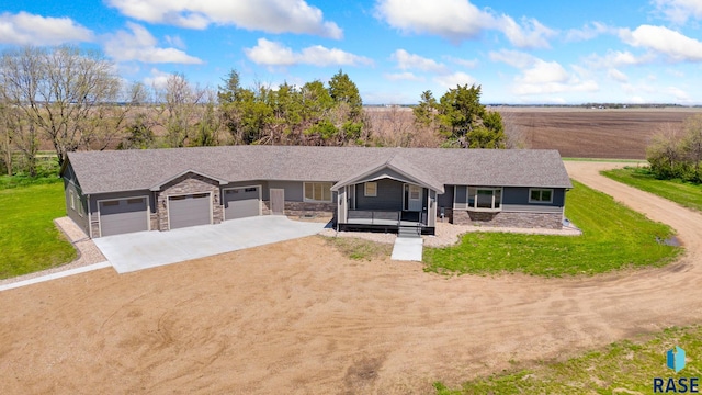 single story home featuring a garage, a front lawn, and covered porch