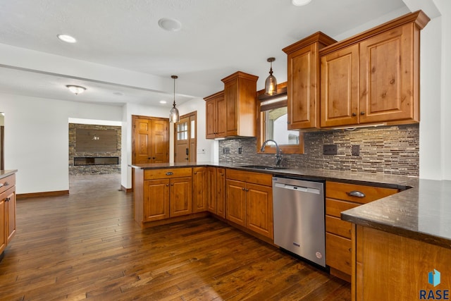 kitchen with dark hardwood / wood-style flooring, dishwasher, hanging light fixtures, tasteful backsplash, and sink