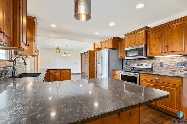 kitchen featuring stainless steel appliances, pendant lighting, dark hardwood / wood-style flooring, backsplash, and sink