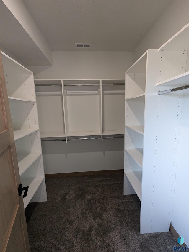 walk in closet featuring visible vents and dark carpet