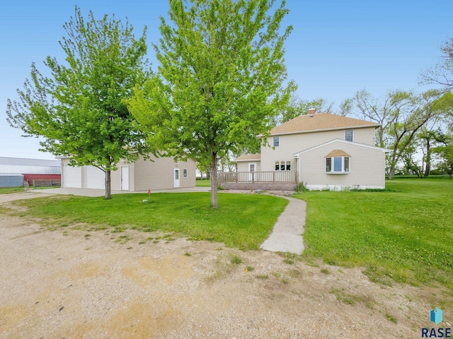 back of house featuring a garage and a yard